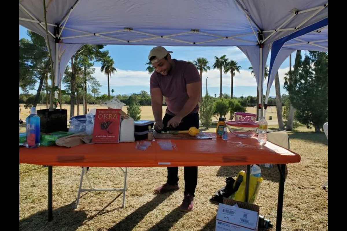 Jordan Collins fixes okra to sample at a Tucson Medical Center tabling event