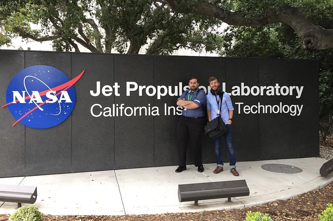 ASU student Robert Amzler poses in front of the JPL sign with a fellow intern