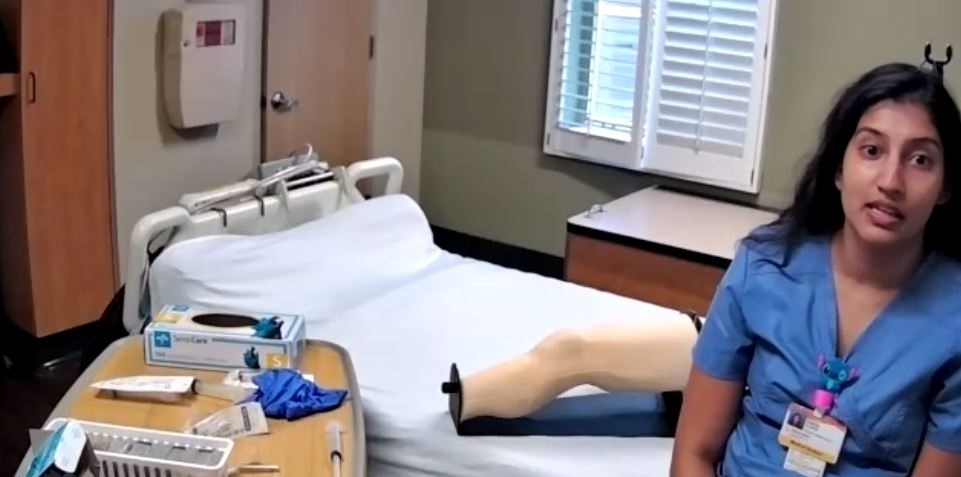 medical student demonstrates knee aspiration procedure