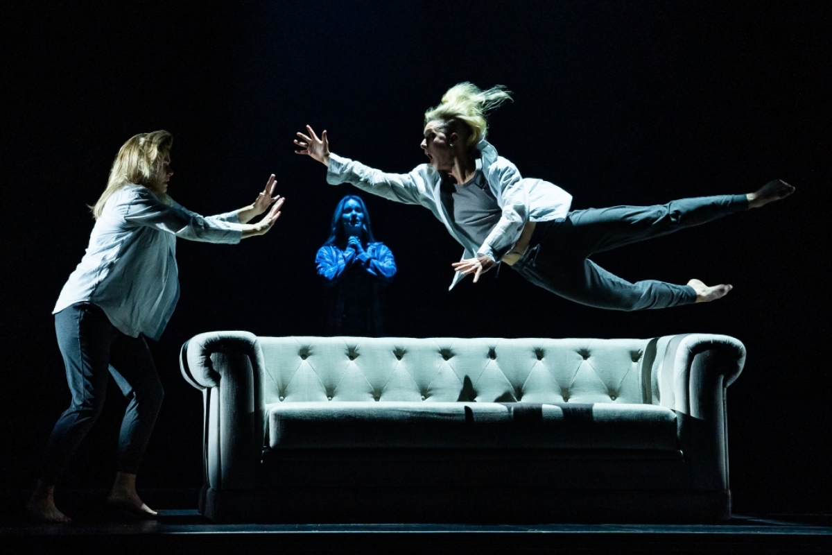 Performers leap onto a couch in a performance of 