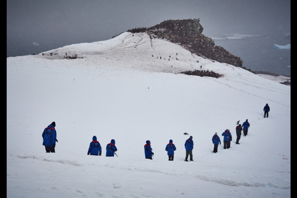 Group of ASU students hiking up a snowy mountain.