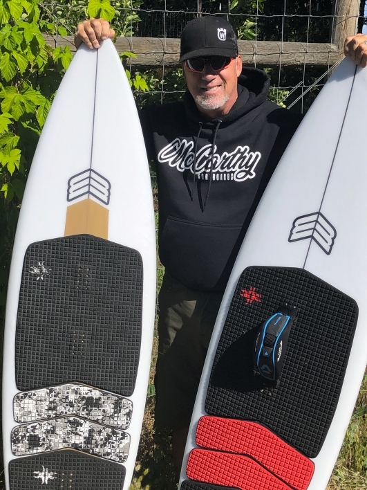 Man holding up two surfboards