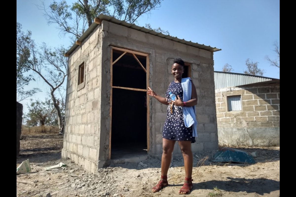 First author Mercy Opiyo in front of a new building