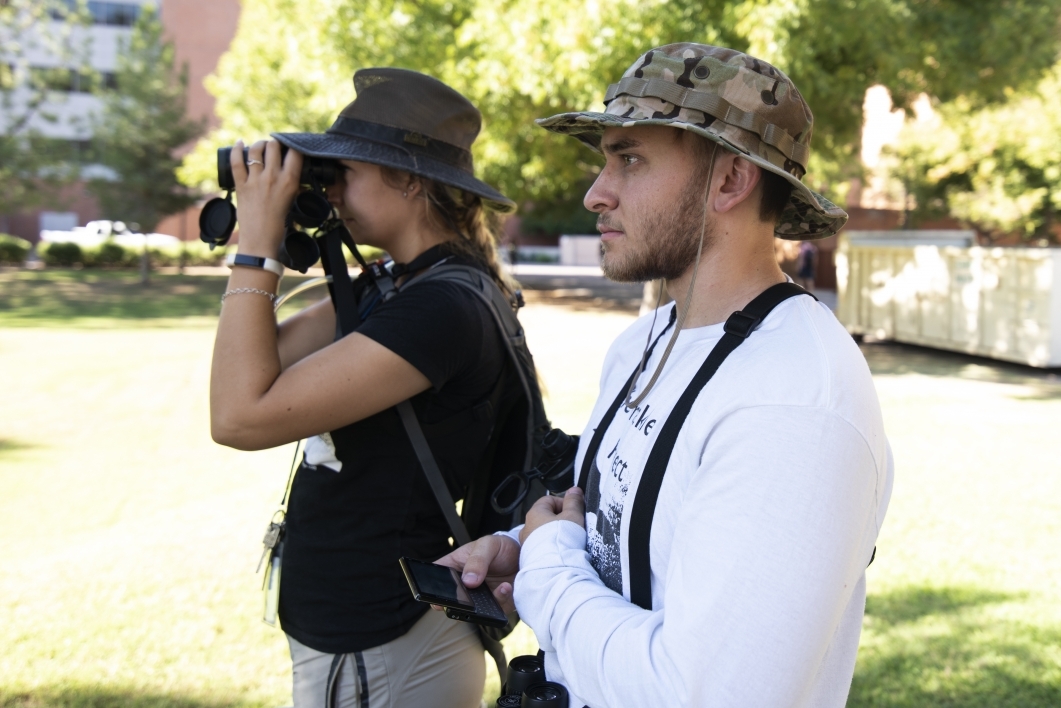 Michael Pickett and Melissa Folsom watch and record the behaviors of a group of color-banded grackles located on the Tempe campus. Folsom collects the observations into a data log of the project's activities at ASU.