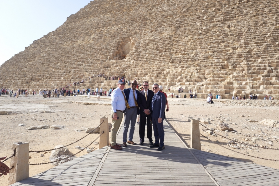 Four men pose in front of one of the pyramids in Egypt
