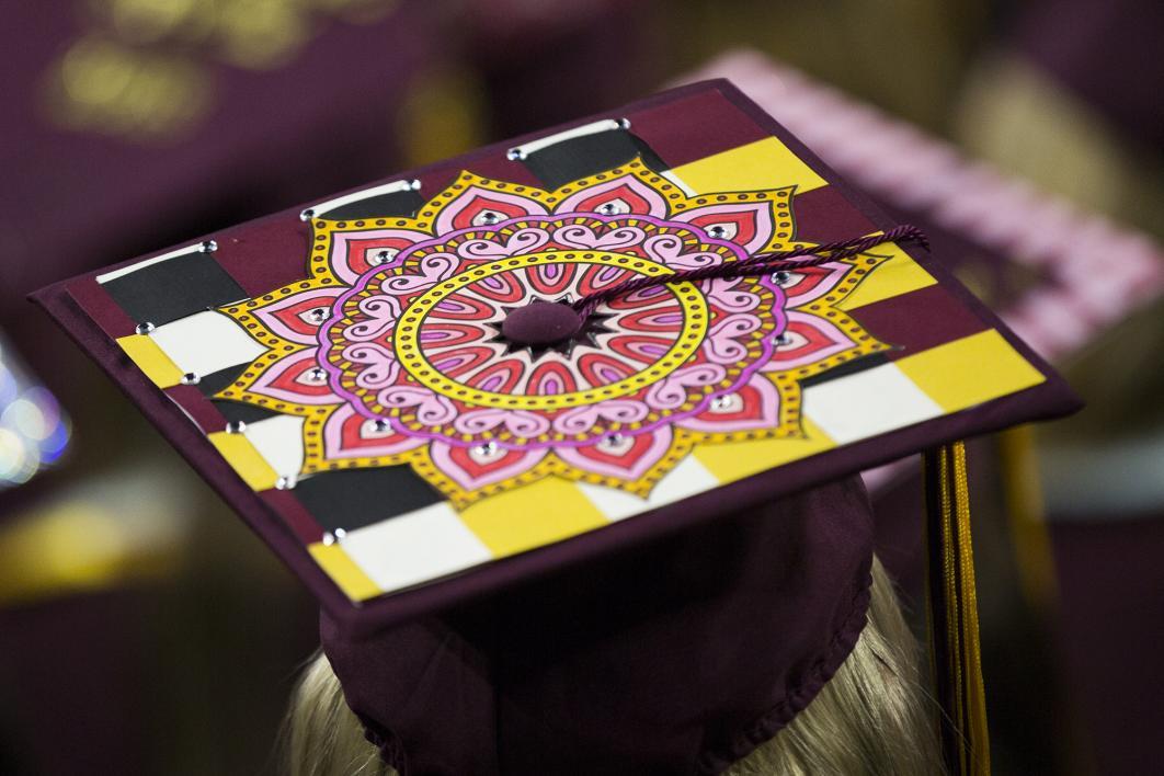 A graduation cap is covered with a pink colored mandala design
