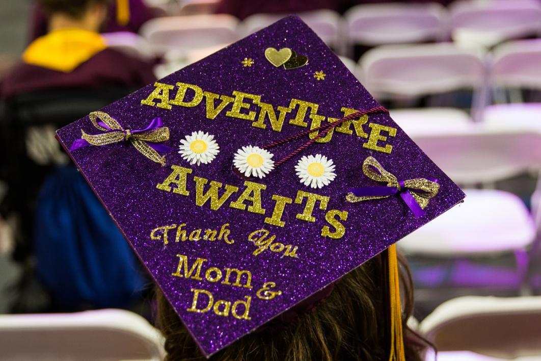 A graduation cap says, 