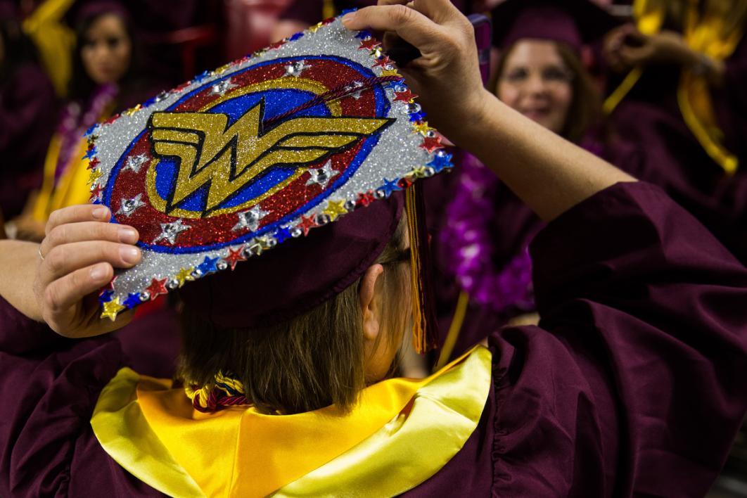 A graduation cap carries the Wonder Woman logo