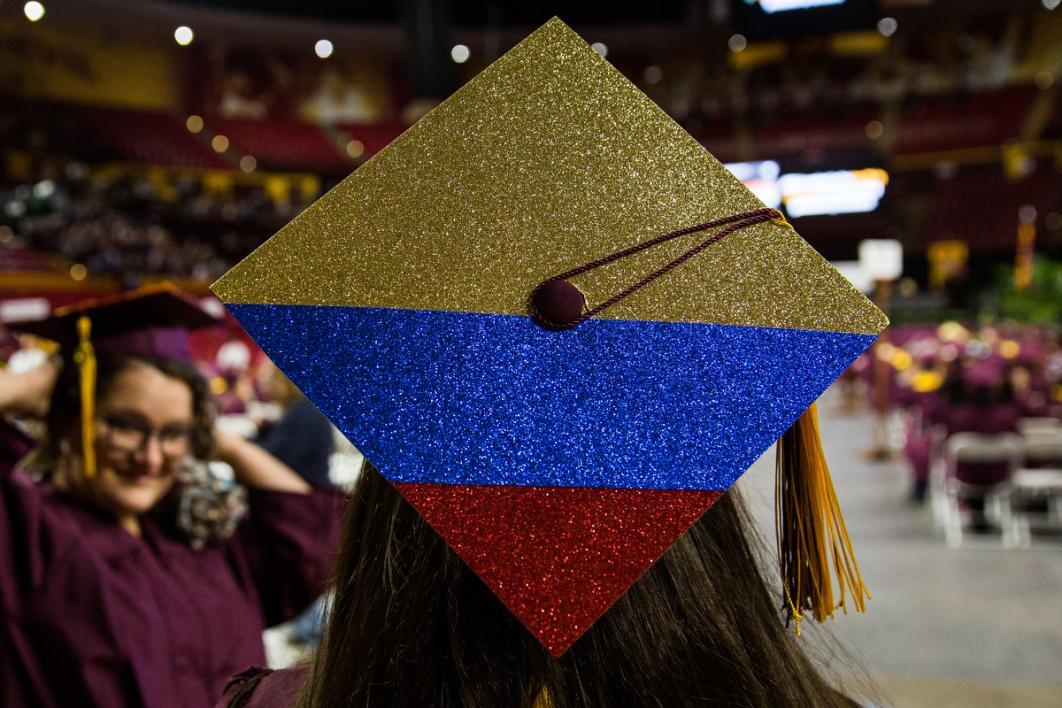 A graduation cap shows a Colombian flag