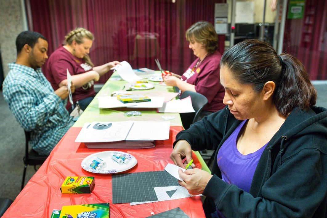 Adults use arts and crafts supplies.
