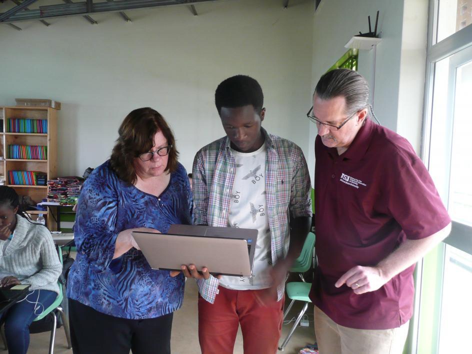 ASU librarians work with a Rwandan student on a laptop
