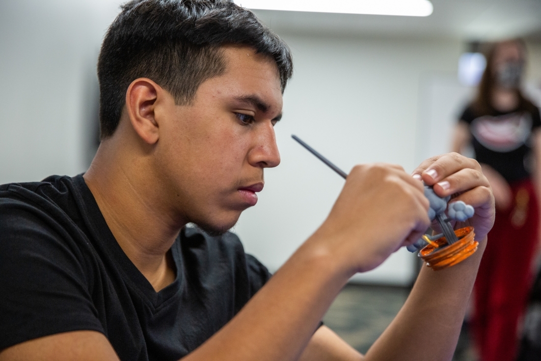 High school student painting a 3D-printed object.