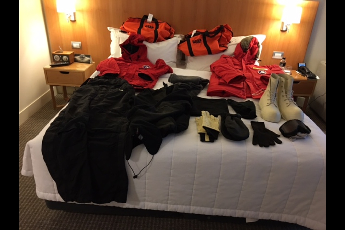 different cold-weather clothing items on a bed