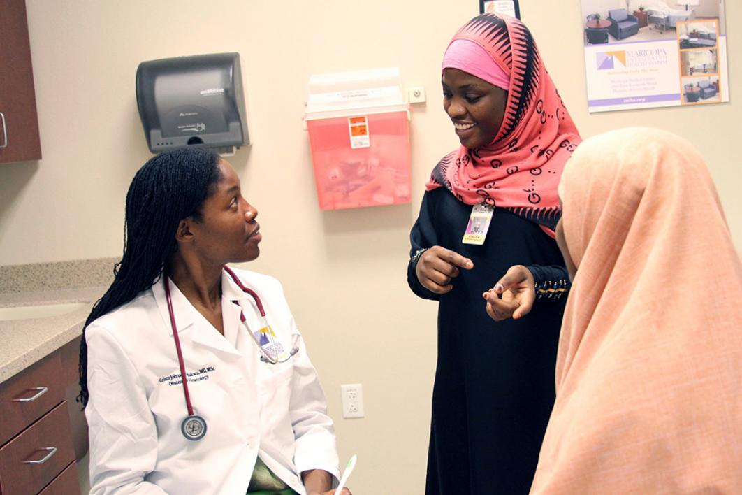 Doctor listens as interpreter translates for a refugee patient