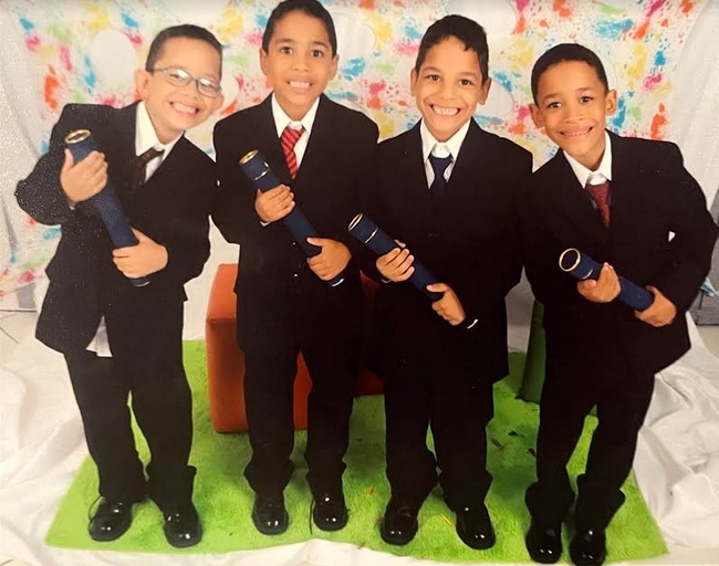 portrait of the De Castro Lopes Francisco quadruplets wearing suits and ties