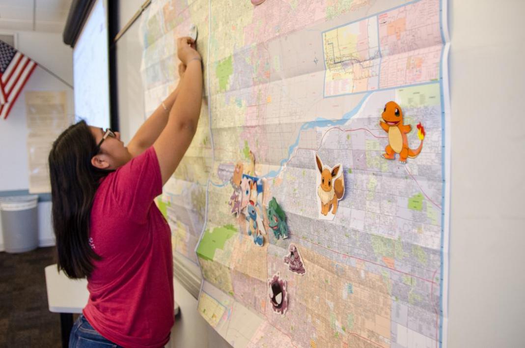 Junior Syndi Flores pins a Pokemon onto a map.