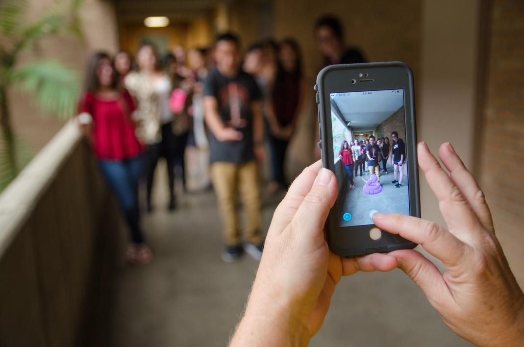 A cellphone takes a photo of a group of students with a Pokemon