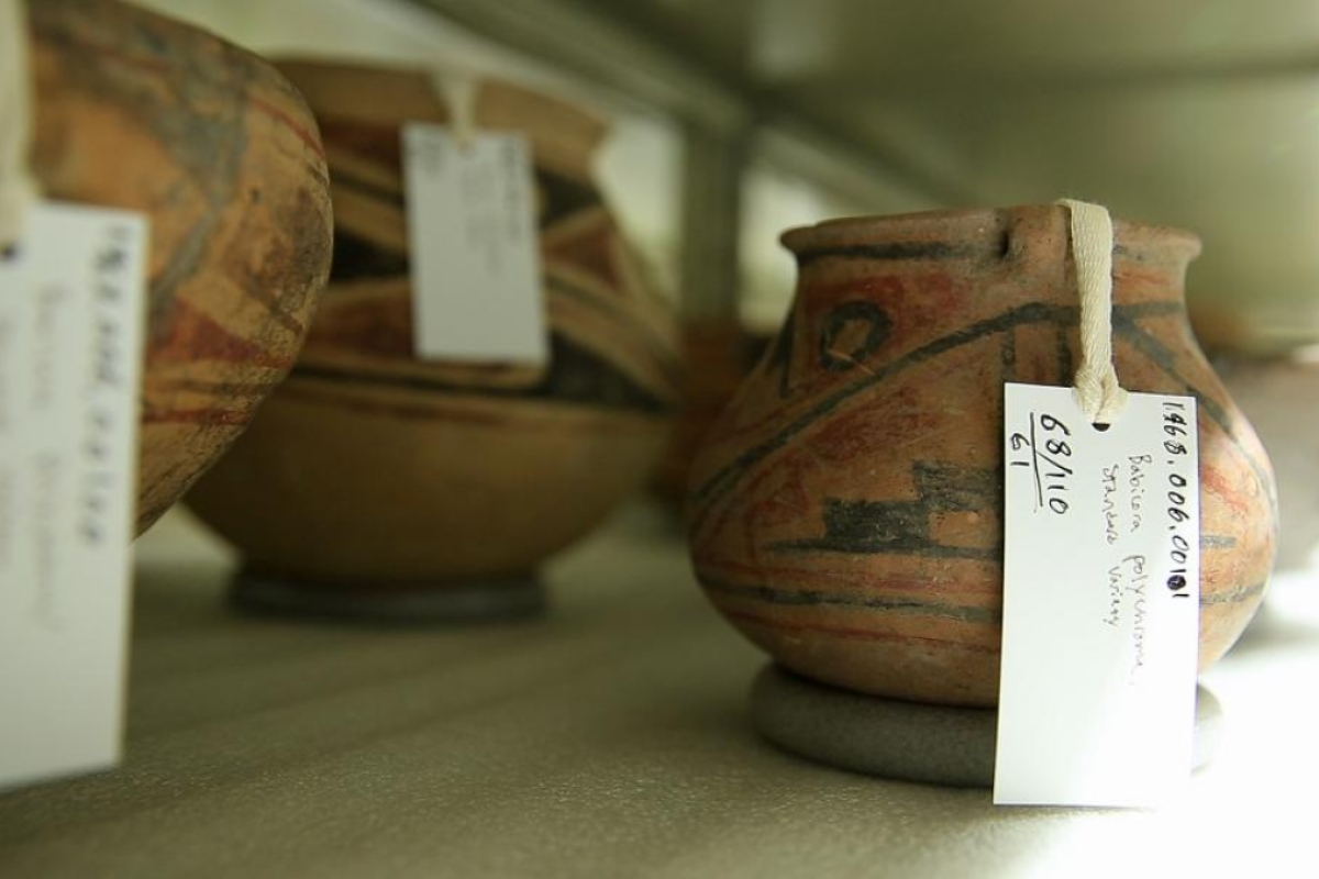 Ancient pots sit on a shelf.