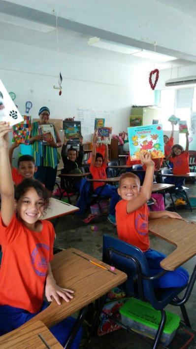 students holding books in classroom