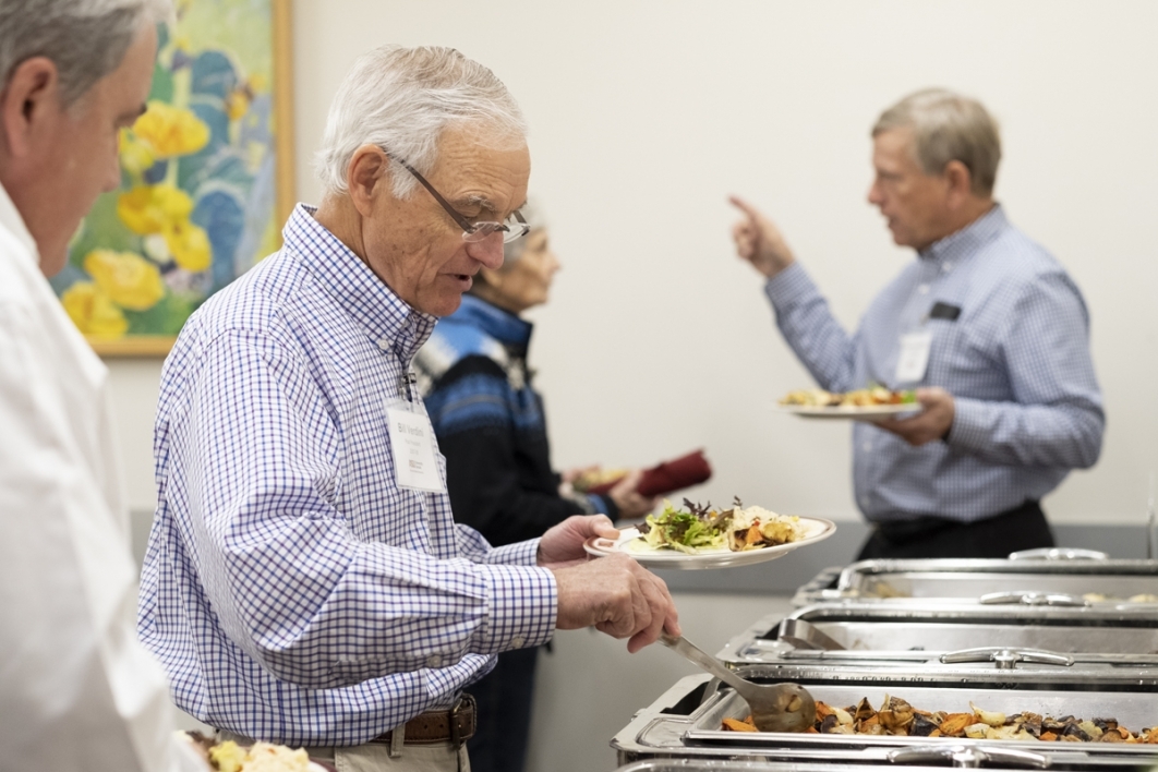man scooping food onto plate
