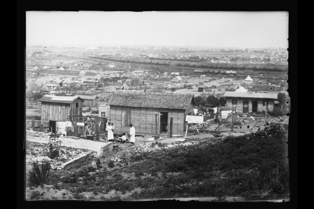 historical photo of small wood building being built on hill