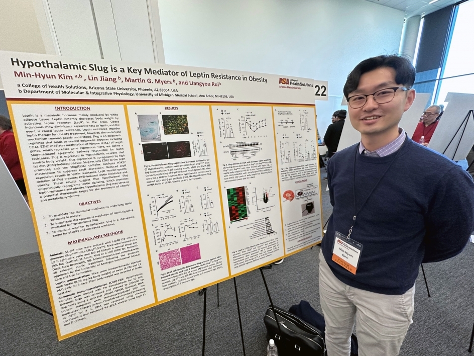 Min-Hyun Kim posing by a poster at Health Solutions Faculty Research Day.
