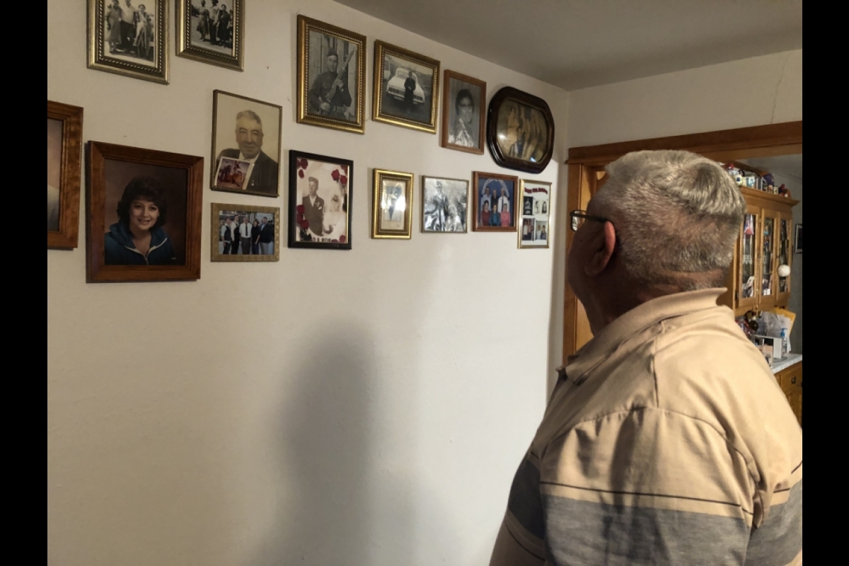Richard Chavez looks at family photos at his home in St. Johns, AZ.