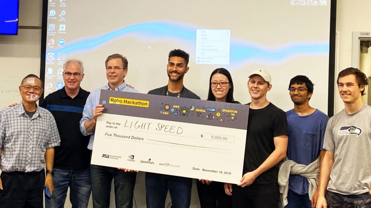Team Light Speed holds their oversized check