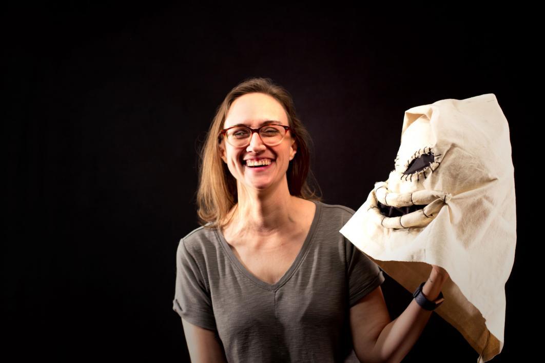 Sarah Lankenau Moench, assistant professor of costume technology, poses with one of the masks made by one of the students in the Upward Bound program
