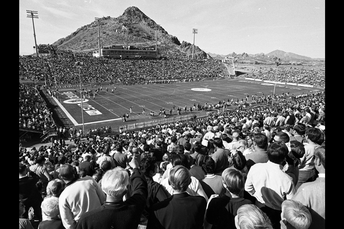 Black and white archived photo of people watching game at ASU football stadium in 1970 with view of A mountain