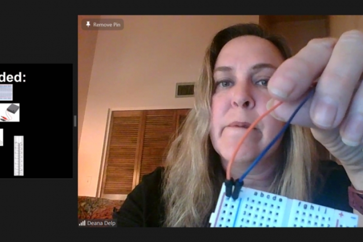 A Zoom screenshot in which Lecturer Deana Delp is holding a bread board and wires and includes a list of supplies needed for a smart rain gauge activity.