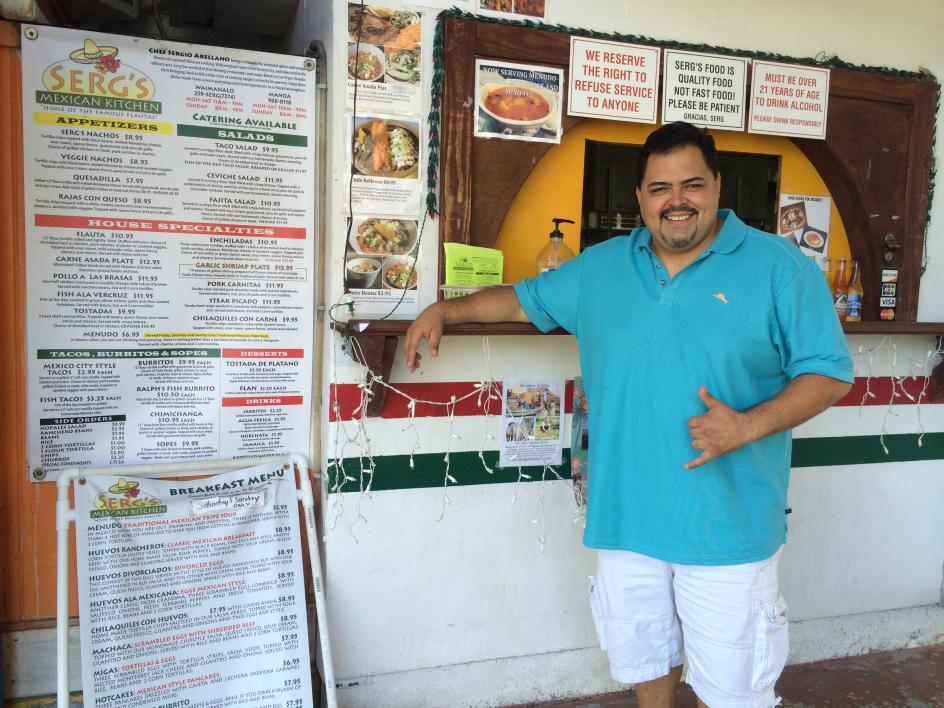 man standing at counter of taco shop