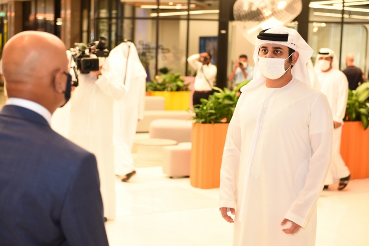 Sheikh Maktoum bin Mohammed wearing a face covering while speaking with Thunderbird Dean Sanjeev Khagram