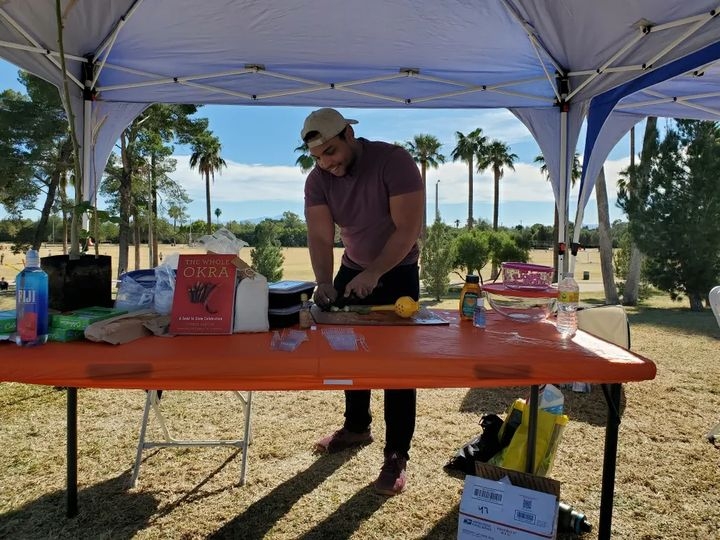 Jordan Collins fixes okra to sample at a Tucson Medical Center tabling event.