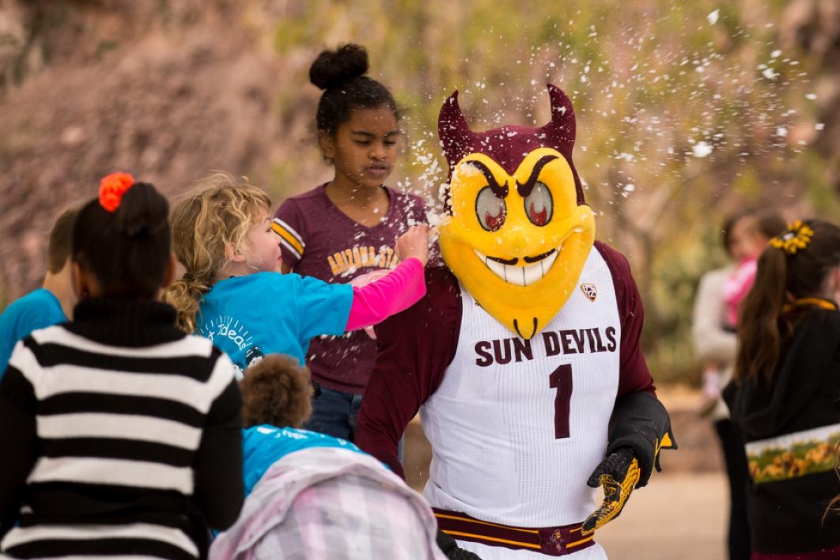 Kids attack a mascot with snow.