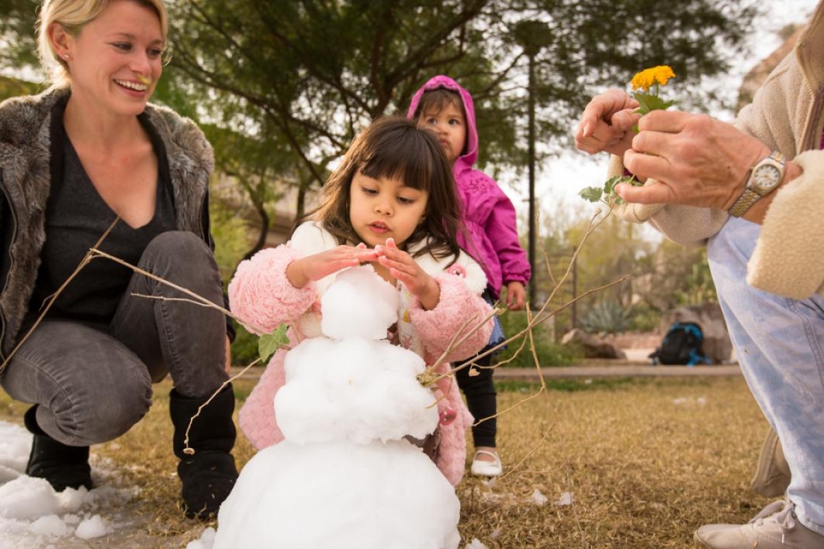 Child builds a snowman.