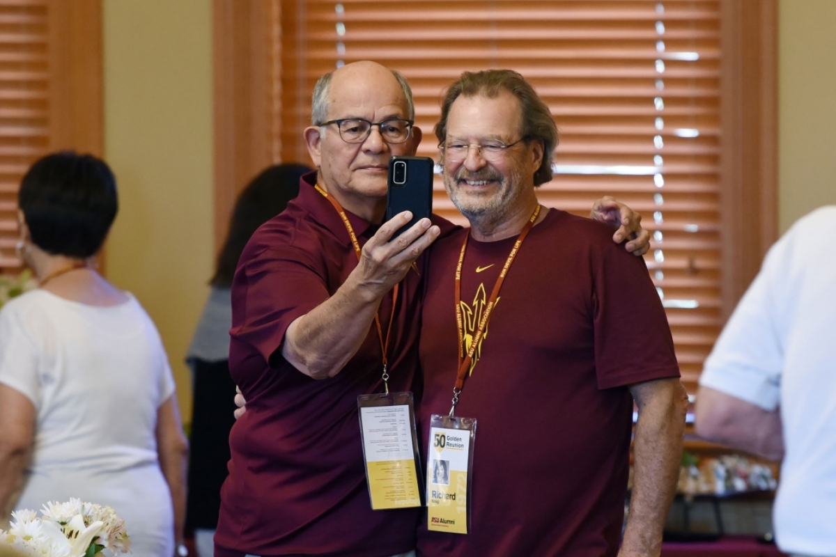 Two men pose for a selfie