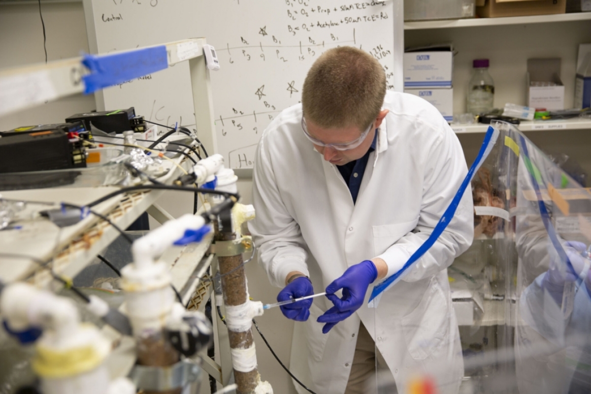 Justin Skinner is pictured working in Assistant Professor Anca Delgado’s lab, taking water samples from an experimental setup.