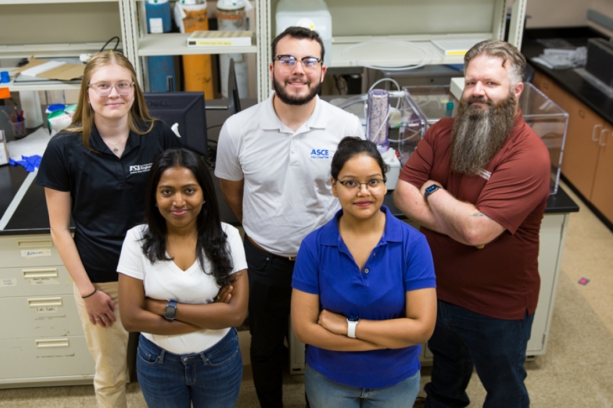Group photo of ASU Assistant Professor Christian Hoover and four students in a lab.