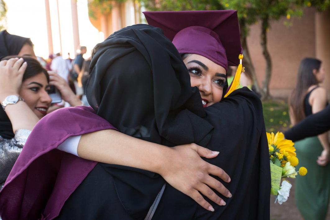 graduate hugging family member