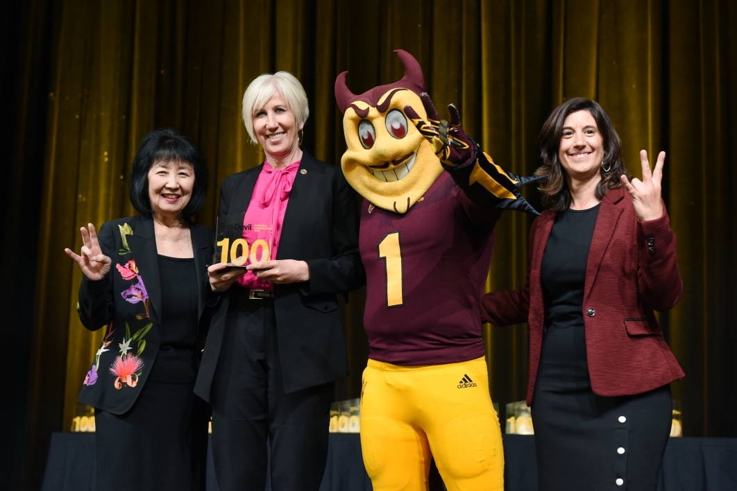three women pose on stage with ASU mascot Sparky the Sun Devil