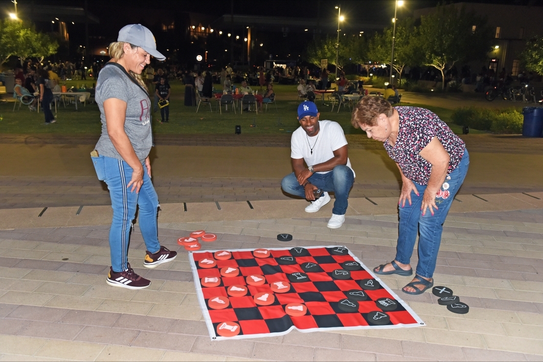 People playing an oversized game of checkers.