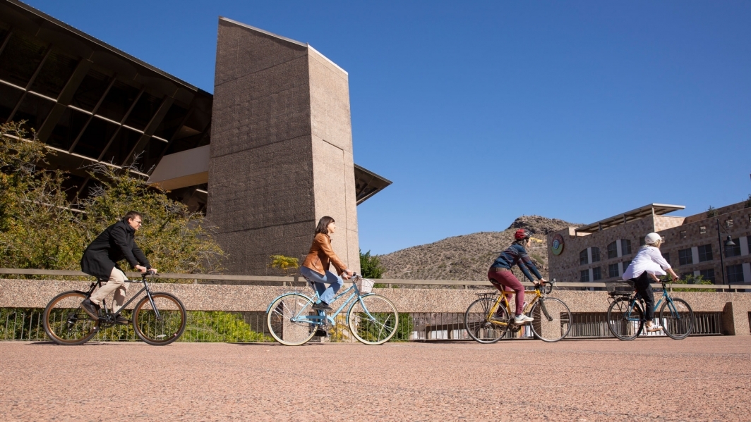 The ASU researchers ride their bikes in front of Tempe City Hall.