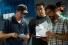 men conferring on script on movie set