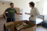 Two men in an apartment with a moving box visible in the front