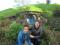 Two people pose in front of a hobbit house