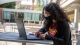 Sabrina Cervantes Villa works on a laptop outside.