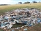 A pile of mixed trash sits on a grassy field.