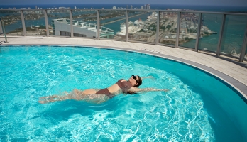 ASU alumna Demi George floats on her back in a rooftop swimming pool