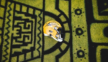 ASU football helmet on football field spray painted with Mayan designs